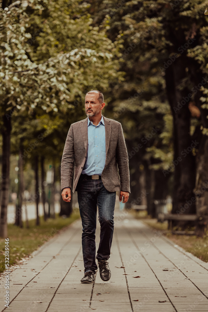 Focused businessman in a suit walking in the park Focused businessman in a suit walking in the park