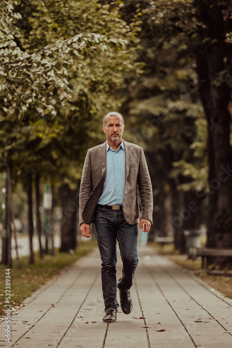 Focused businessman in a suit walking in the park