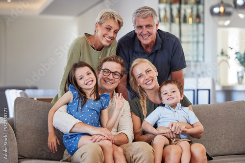 Big family, love and smile of children, parents and grandparent sharing a bond and support while sitting on sofa at home. Portrait, happiness and multi generation men and woman spending time together