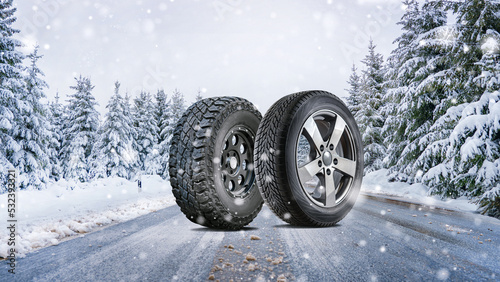 close up different winter tires on a snowy road in the mountains - snow storm photo