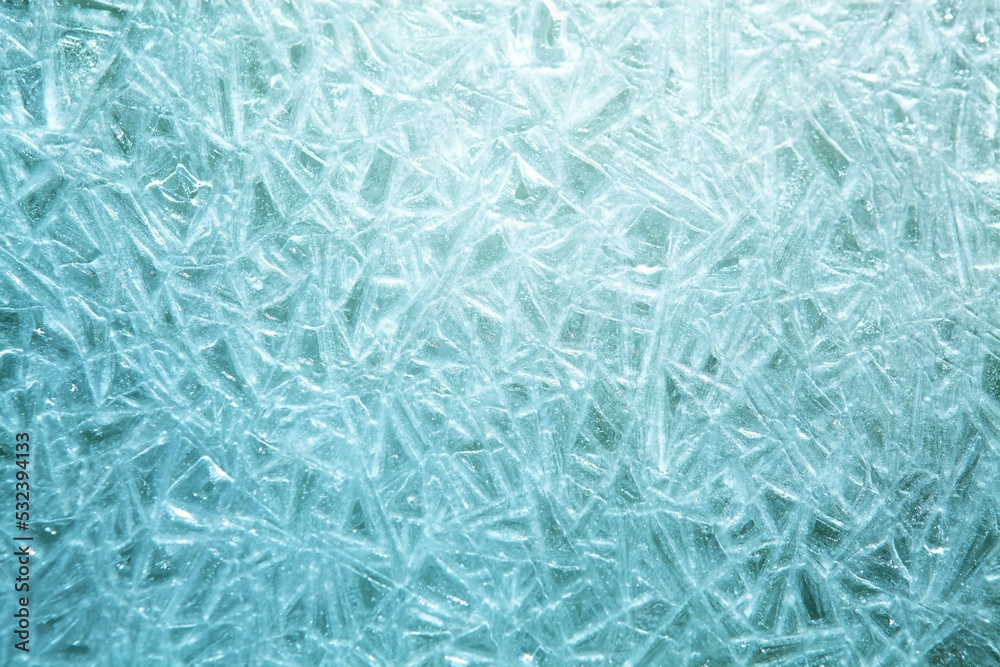 The texture of the ice surface. Winter background, festive background in the form of ice crystals, in natural deep blue color.