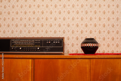 Vintage Komode mit Radio und Vase vor Tapete