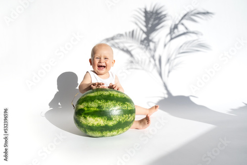Cute baby, child, kid emotins. Funny toddler boy playing with watermelon, healthy fruit snack on white background, hot summer day. Organic vegan healthy diet, feeding, solid food concept. Copy space