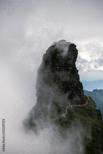 Fanjingshan mountain scenery with view of the new golden summit with Buddhist temple on the top in the dense clouds in Guizhou China, vertical image with copy space for text