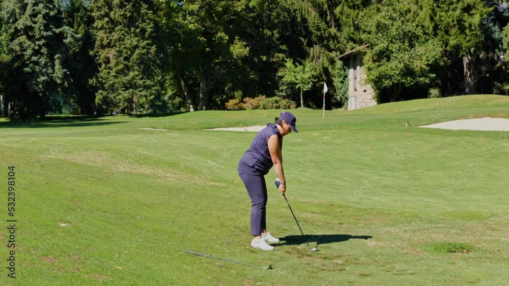 Golfer Chipping the Golf Ball to the Putting Green in a Sunny Day in Lugano, Ticino, Switzerland. Golfer Chipping the Golf Ball to the Putting Green in a Sunny Day in Lugano, Ticino, Switzerland.