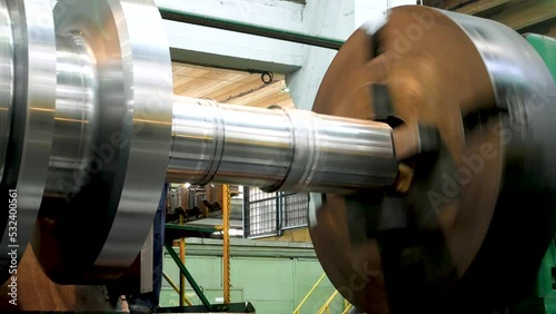 A large rotating metal part on a machine in the workshop of a metallurgical plant. Heavy industry and metallurgy photo