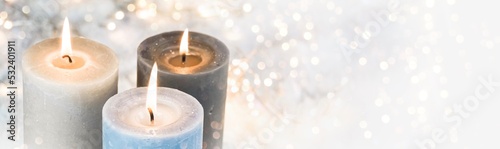 Christmas background - burning advent candles in the snow with golden bokeh lights - wintry xmas decoration - panorama, header 