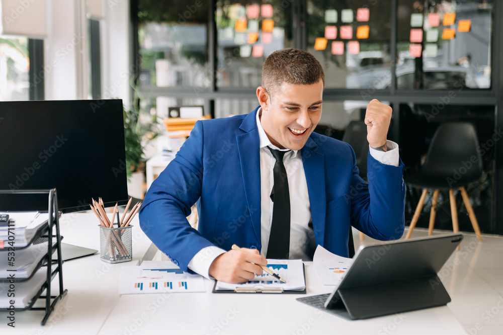© Nuttapong punna - Business man are delighted and happy with the work they do on their tablet, laptop and taking notes at the modern office.