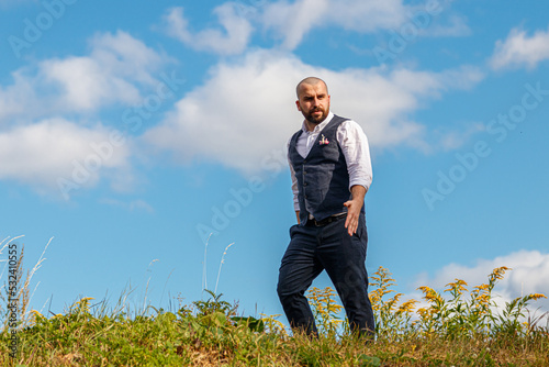 handsome guy in a suit among the field against the blue sky © Minakryn Ruslan 