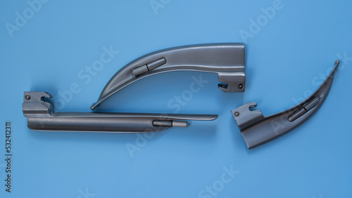 set for intubation of the trachea  blades for a laryngoscope of different sizes lie on a blue background close-up