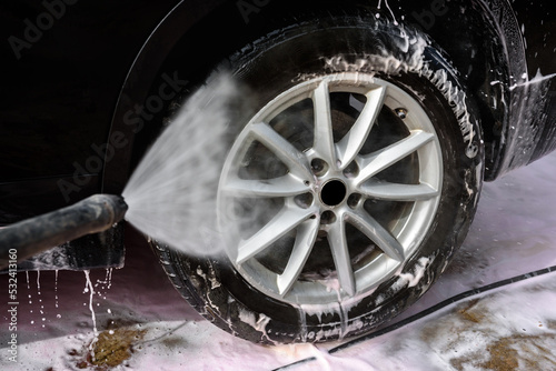 Manual car wash with high pressure washing outside.