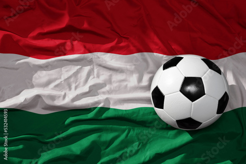vintage football ball on the waveing national flag of hungary background. 3D illustration