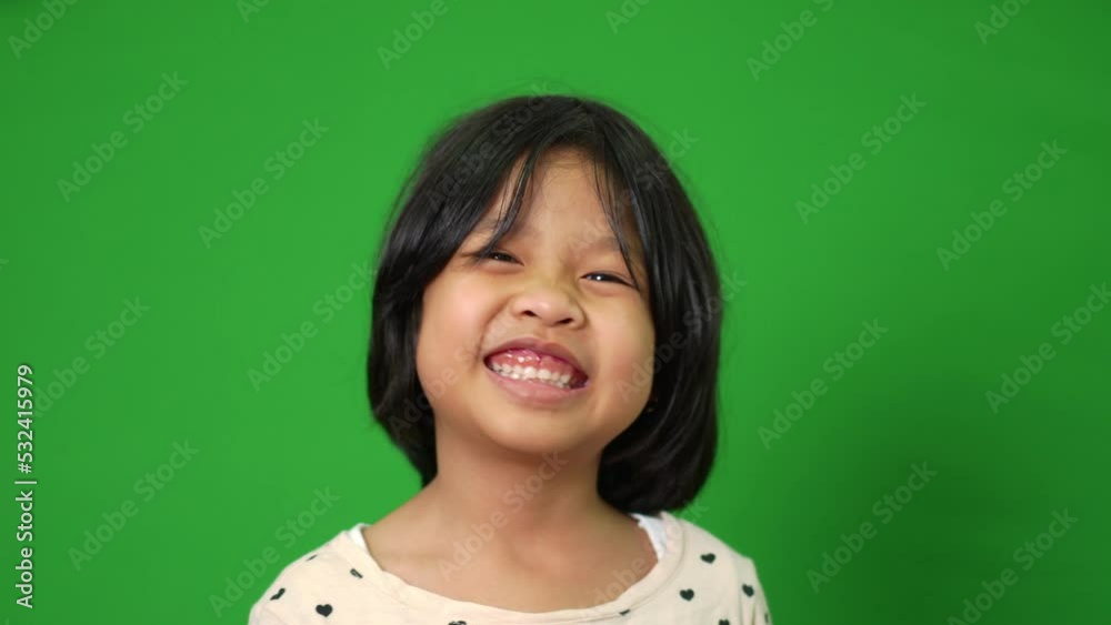 Portrait of happy, smiling, and funny Asian child girl on green screen background, a child looking at camera. Preschool kid dreaming fill with energy feeling healthy and good concept Portrait of happy, smiling, and funny Asian child girl on green screen background, a child looking at camera. Preschool kid dreaming fill with energy feeling healthy and good concept