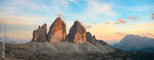 Stunning panoramic view of the Three Peaks of Lavaredo, (Tre cime di Lavaredo) Mount Paterno and a refuge during a beautiful sunset photo