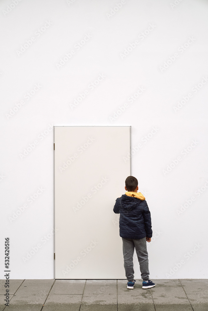 Little fashionable boy posing in front of white concrete wall. Concept of style and fashion for children Little fashionable boy posing in front of white concrete wall. Concept of style and fashion for children