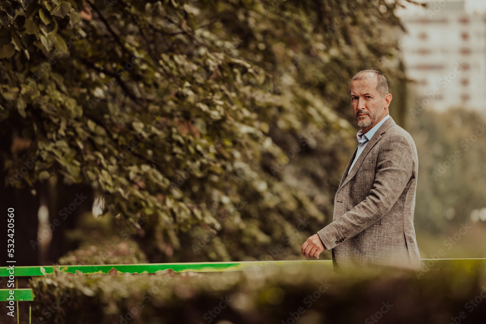 Focused businessman in a suit walking in the park Focused businessman in a suit walking in the park