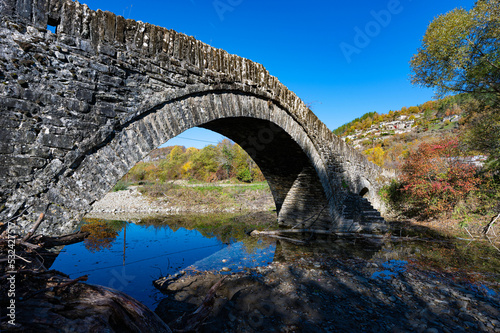 View of the traditional stone Mylos Bridge in Epirus, Greece in Autumn.
