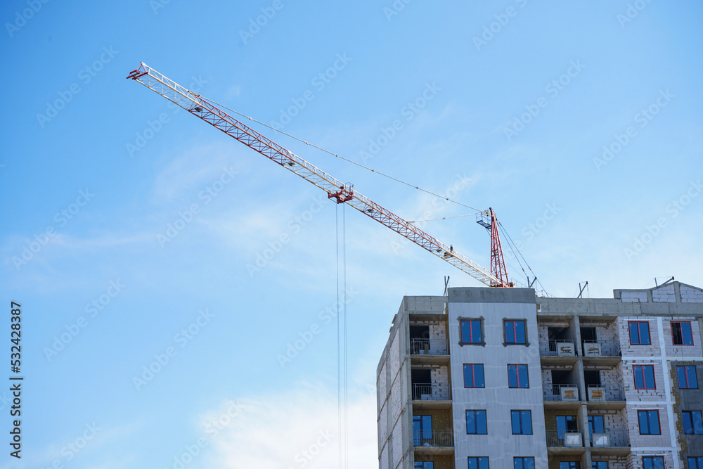 Construction of a residential building and a high-rise crane. Building site. Construction of a residential building and a high-rise crane. Building site.