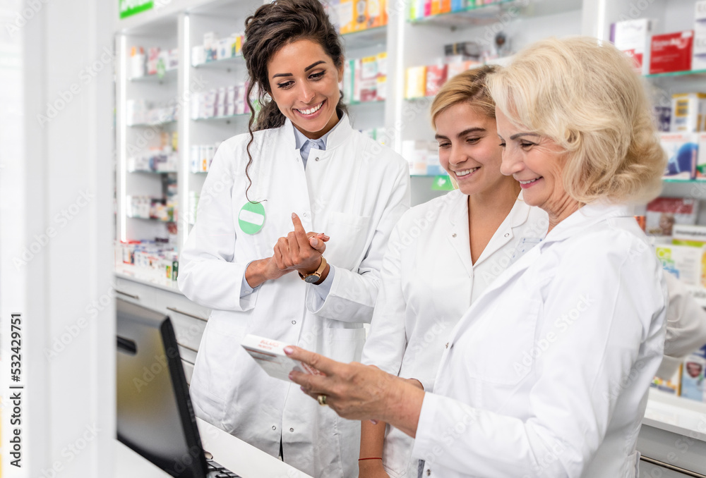 Three female pharmacist working in drugstore.