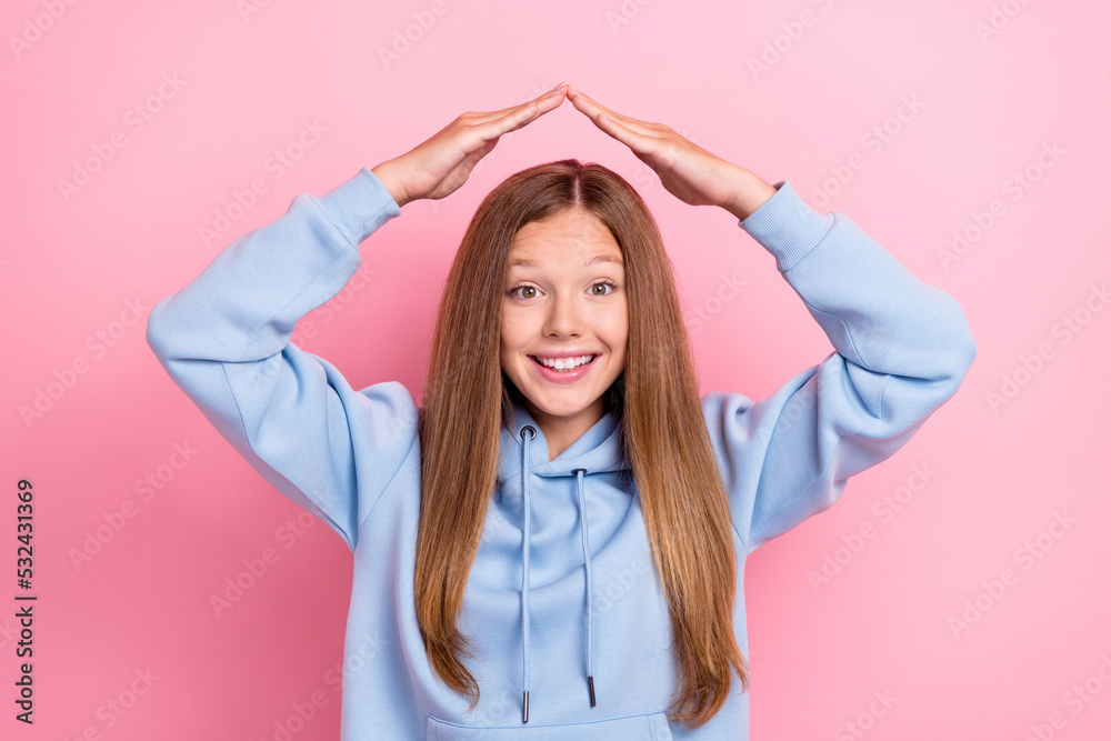 Photo of young funny positive toothy smile little girl hold house hands protection excited wear blue hoodie isolated on bright pink color background Photo of young funny positive toothy smile little girl hold house hands protection excited wear blue hoodie isolated on bright pink color background