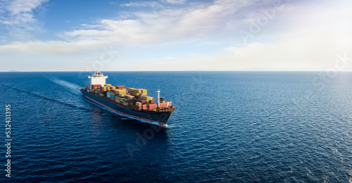 Obraz na płótnie Panoramic aerial view of a cargo ship carrying containers for import and export, business logistic and transportation in open sea with copy space w salonie