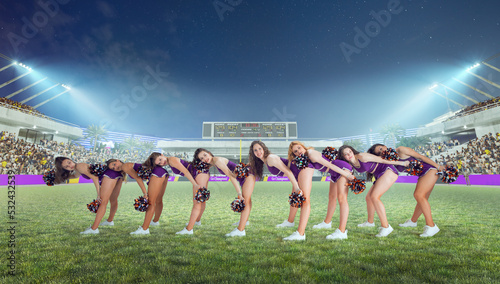 Group of cheerleaders in action on  stadium in night