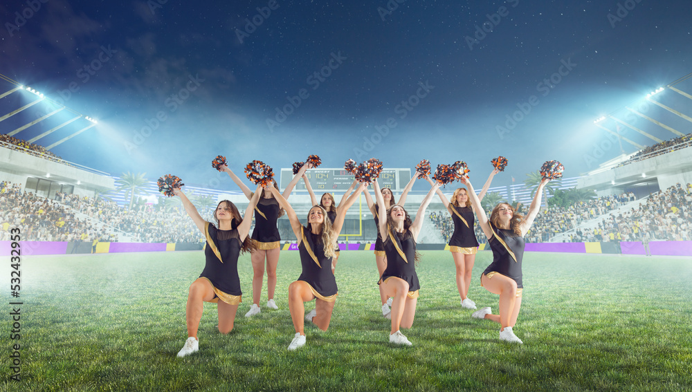 Group of cheerleaders in action on  stadium in night - obrazy, fototapety, plakaty 