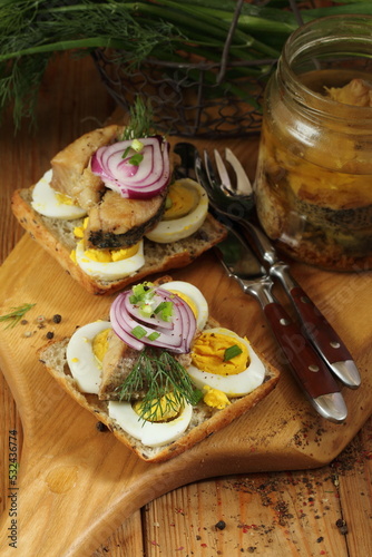 Sandwiches with canned pike and egg on a wooden table