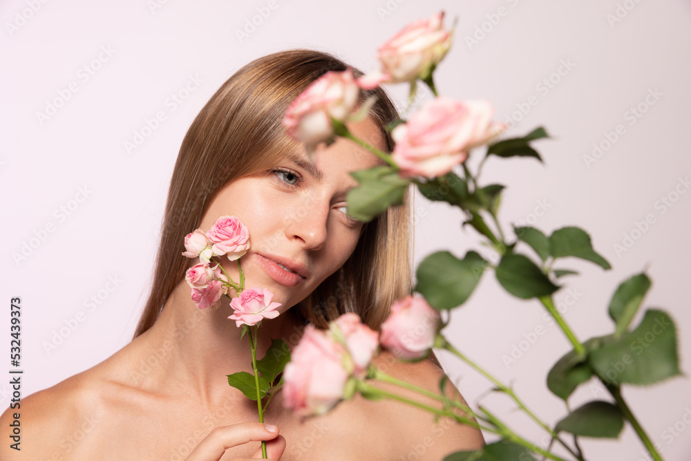 Spring. Beautiful young girl with glossy blond hair holding flower isolated over white background. Shapes and lines, cosmetics, natural beauty Spring. Beautiful young girl with glossy blond hair holding flower isolated over white background. Shapes and lines, cosmetics, natural beauty
