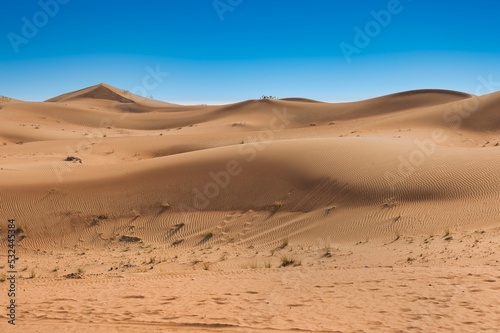 Landscape photo of desert and sand dune under the clear blue sky in Dubai, UAE