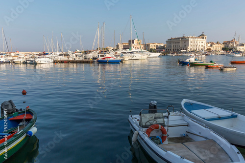 Marina with large yachts and wooden boats in the southern port city on a sunny bright day. Hotel building on the beach  beautiful scenery.