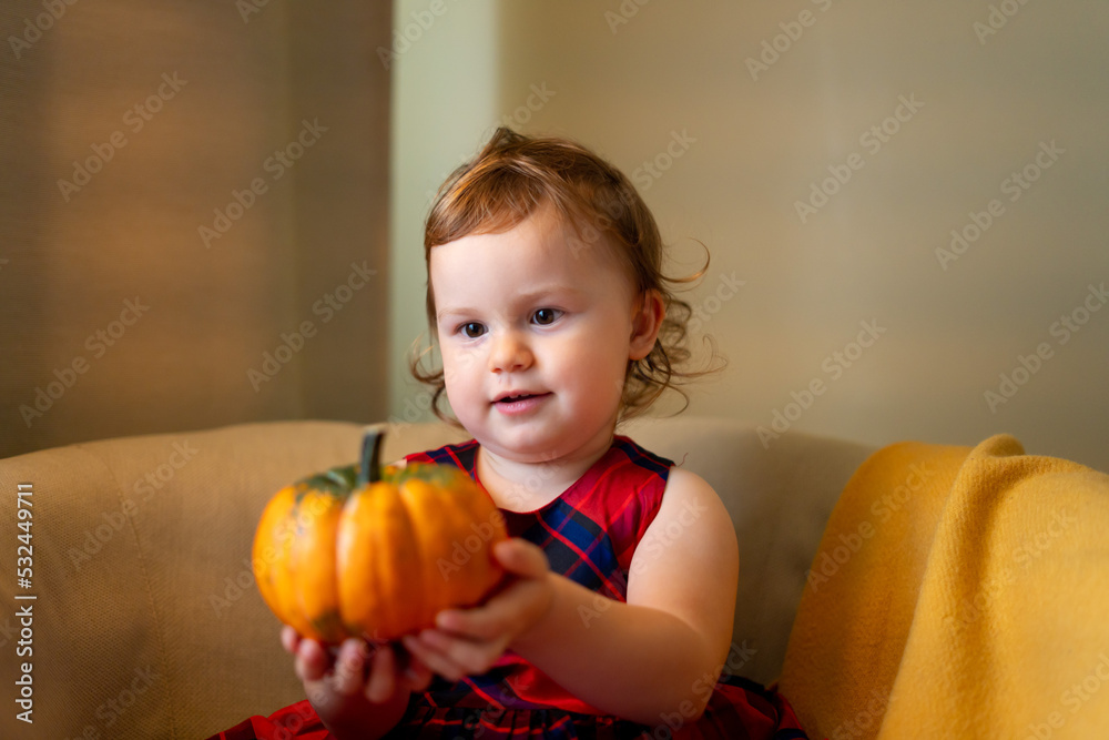 Fototapeta premium happy baby with a pumpkin for Halloween home