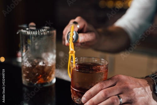 close up of barman decorate negro martini cocktail