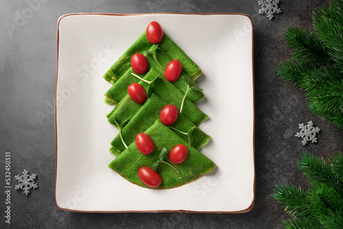 Fotótapéta Christmas tree of vegan spinach crepes on ceramic plate
