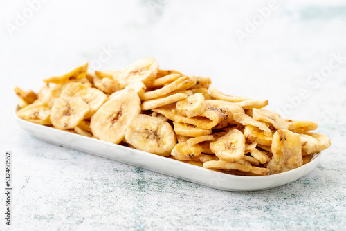 Dried banana slice on gray background. Dried fruit in sunlight. close up
