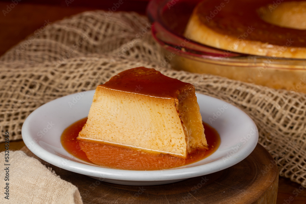 Milk pudding on white plate in rustic setting. Milk pudding on white plate in rustic setting.