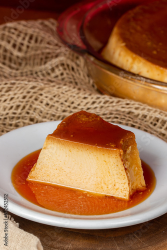 Milk pudding on white plate in rustic setting photo