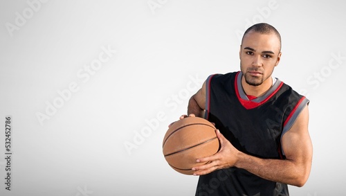 Young male basketball player holding ball, sports lifestyle. © BillionPhotos.com