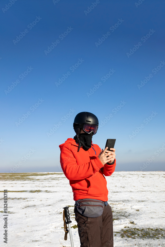 Skier using his smartphone in the mountains