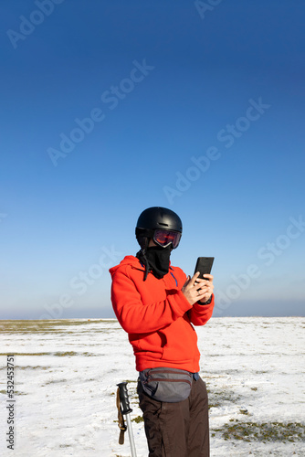 Skier using his smartphone in the mountains