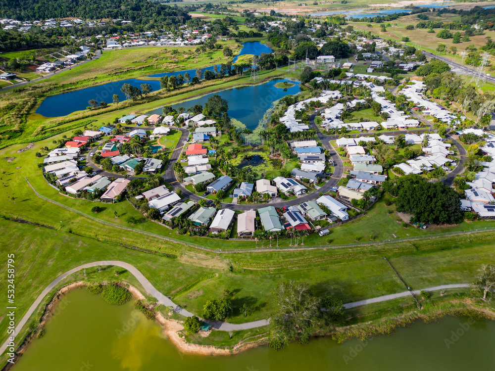 Aerial view of tropical housing estate with a lake and green souroundings