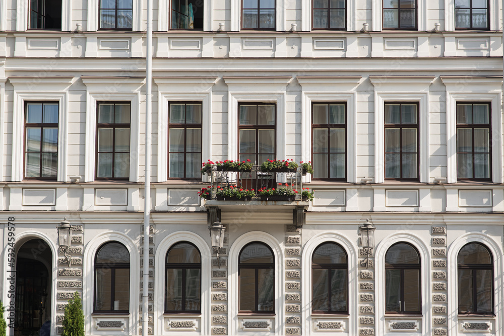 View of the facade of the house with windows and a balcony. View of the facade of the house with windows and a balcony.