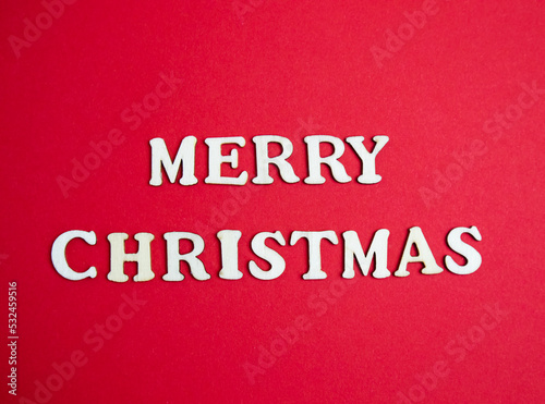 Merry christmas lettering with wooden letters on red background.Postcard from natural, eco. Holiday concept, banner, congratulation, invitation, announcement, advertisement, business, poster, template