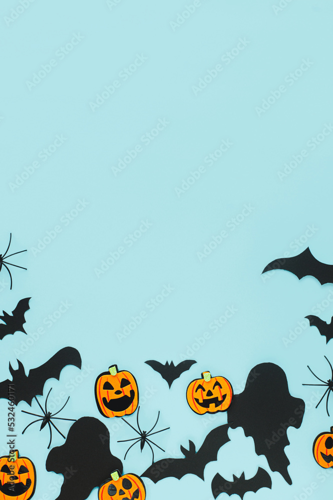 Halloween. Black ghosts, spiders, bats and orange pumpkins decorations on blue background flat lay. Happy Halloween! Card template with space for text. Modern minimal border Halloween. Black ghosts, spiders, bats and orange pumpkins decorations on blue background flat lay. Happy Halloween! Card template with space for text. Modern minimal border