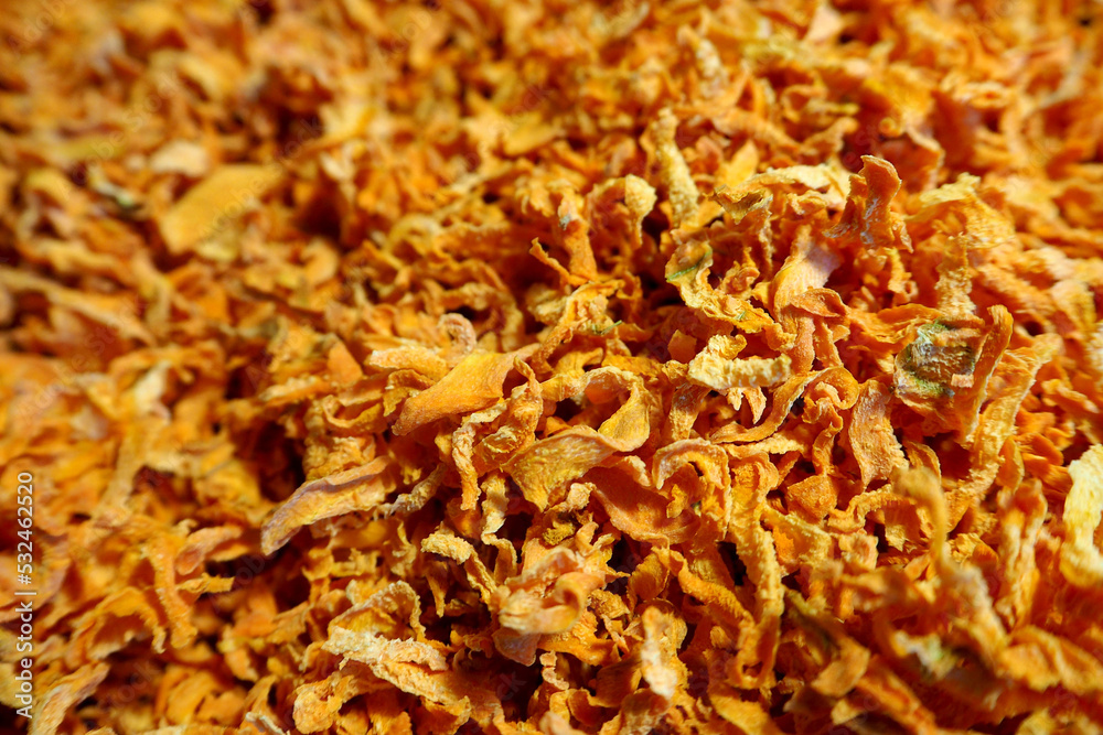 a lot of orange dried carrots close up. side view. dried vegetables. dry carrot pieces a lot of orange dried carrots close up. side view. dried vegetables. dry carrot pieces