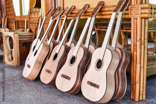 Many unfinished wooden drying guitars in workshop photo