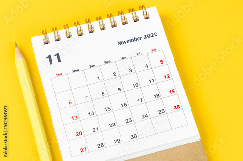 The November 2022 Monthly desk calendar for 2022 with pencil on yellow background.