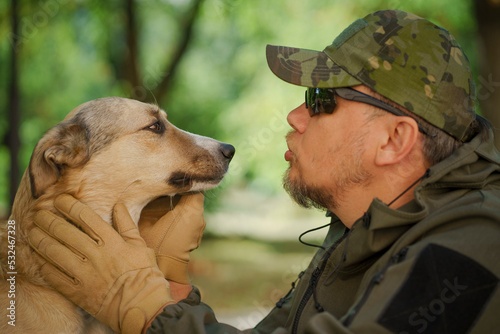 Photography Profile portrait of Man in military uniform with dog outdoors looking into eyes eachothers