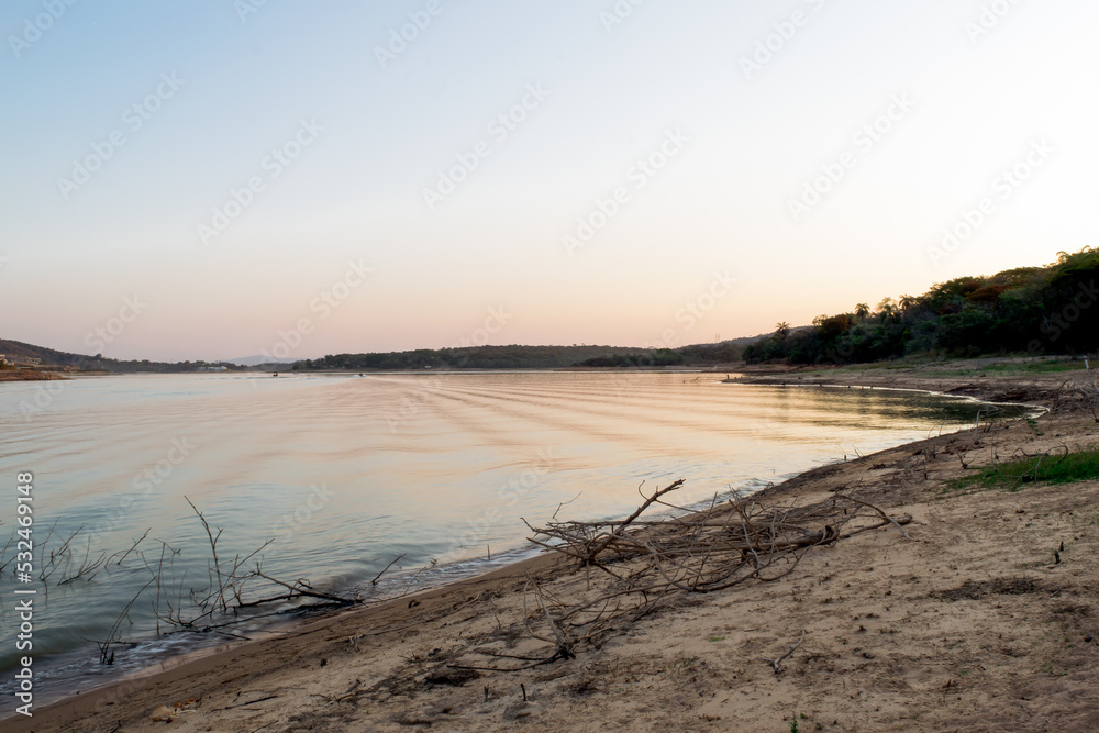 Linda paisagem, com céu dourado e limpo, e ao fundo a praia de água doce da represa da Várzea das Flores, em Contagem, Minas Gerais.