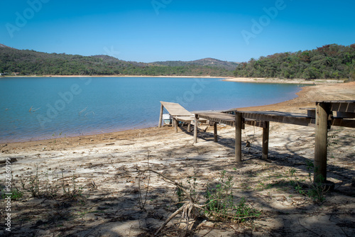 Linda manhã, com vista para pequeno pier em época de seca, céu azul e limpo, e sem neblina na praia de água doce da represa da Várzea das Flores, em Contagem, Minas Gerais, Brasil.